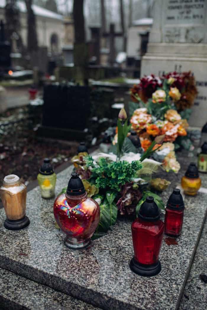 A peaceful cemetery grave adorned with colorful lanterns and flowers, evoking a sense of remembrance.